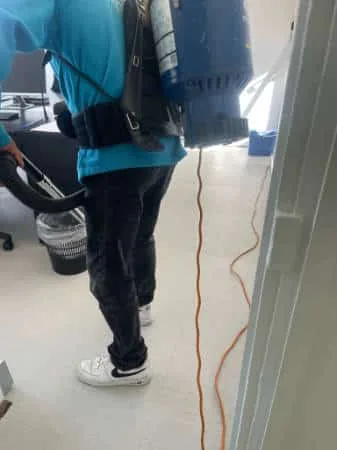 Agent NPG aspirant la moquette de bureaux dans l'Essonne