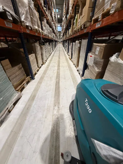 Nettoyage d'une allée de circulation d'entrepôt logistique dans l'Essonne